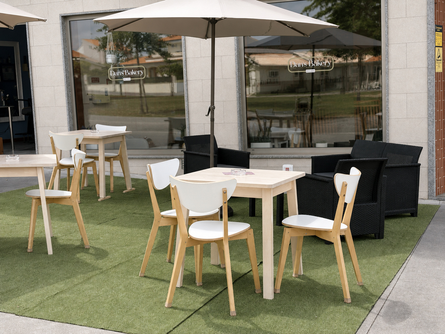Esplanada da Dan's Bakery com mesas, cadeiras e chapéus de sol